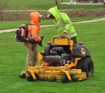 Two men using lawn mower