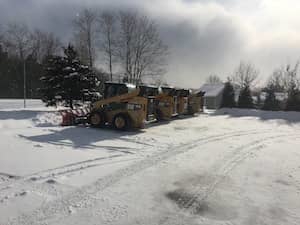 Four skid-steer loaders, equipped for snow removal
