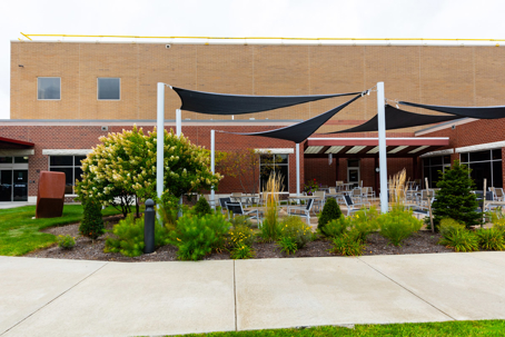 outdoor patio features black fabric shades over seating areas