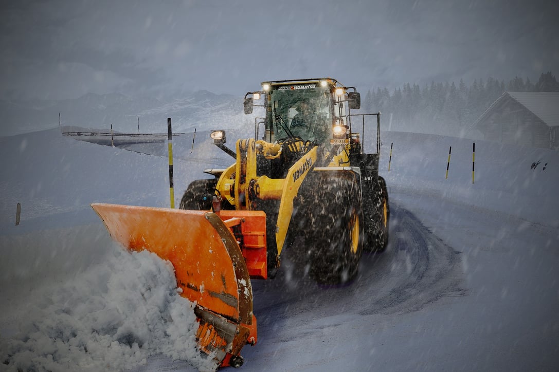 front loader pushes snow on driveway