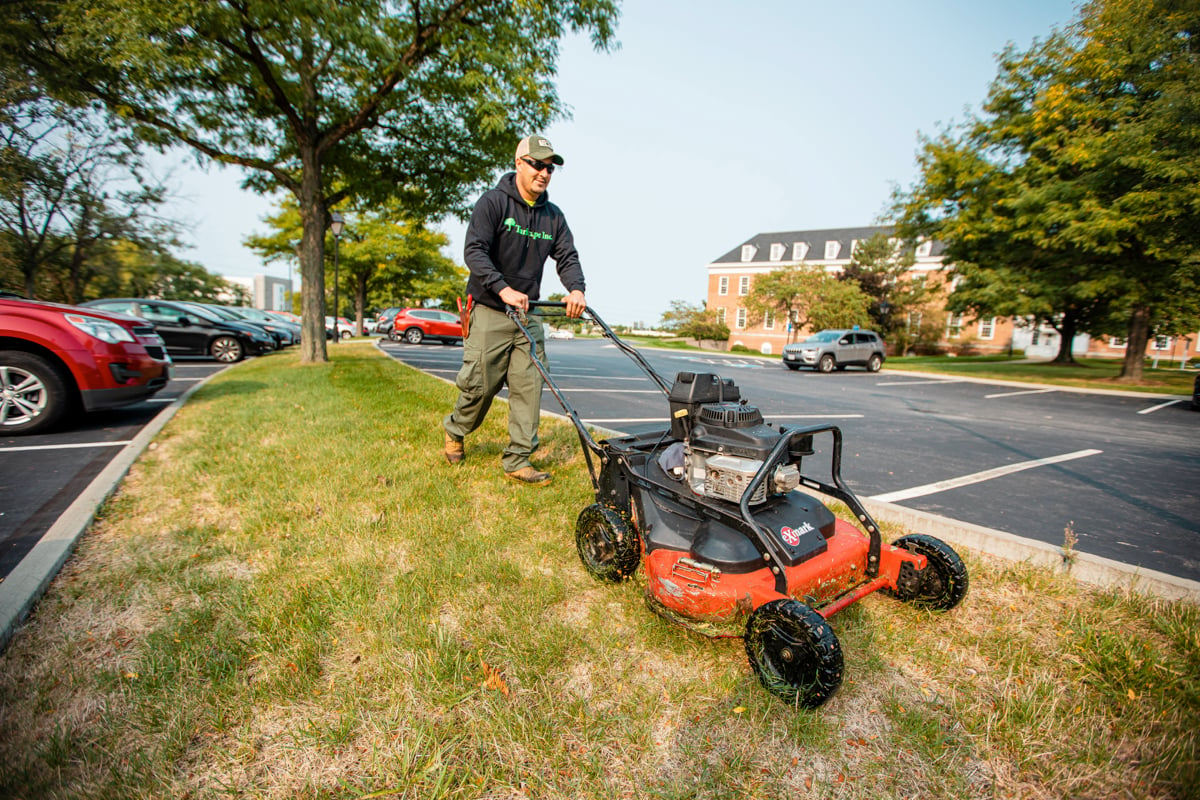 Commercial Landscaping Crew mowing along a parking lot