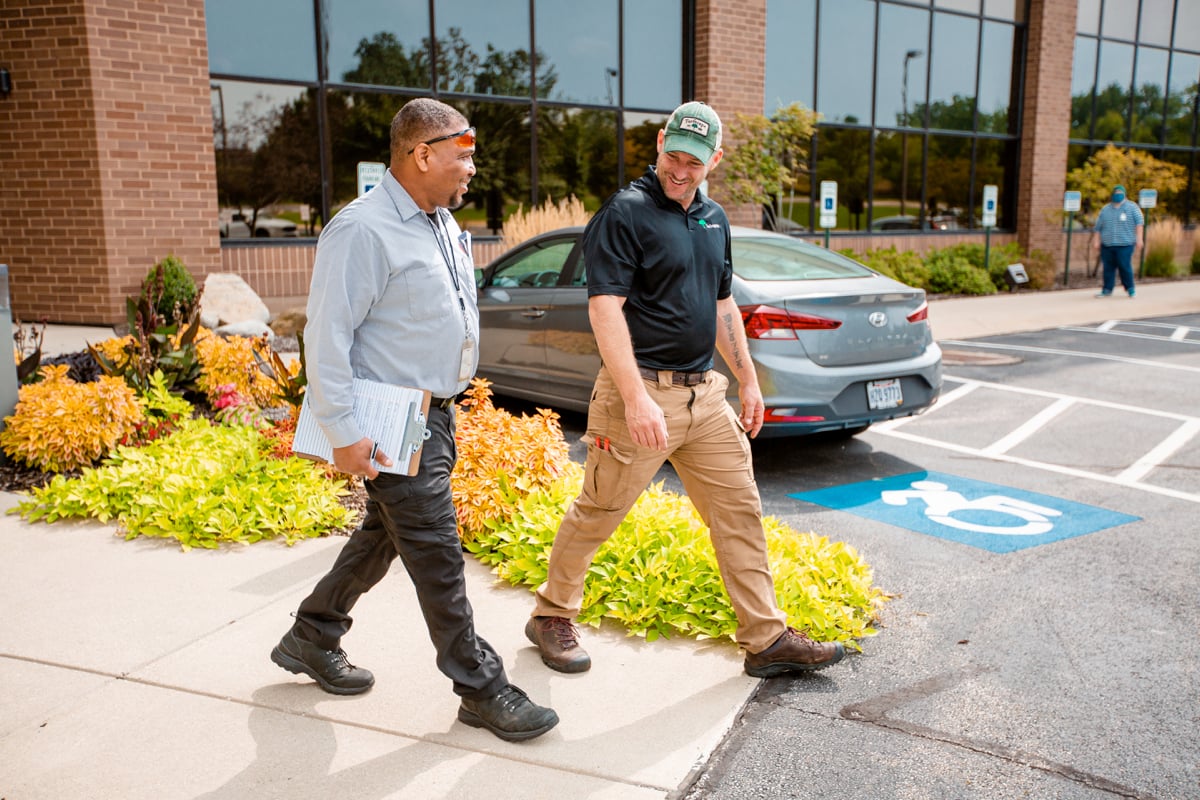 commercial landscaping account manager inspects property with property manager