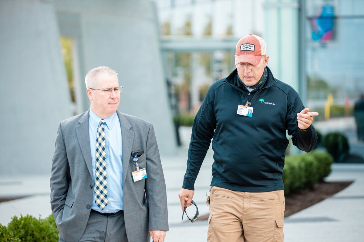 account manager and property manager inspect landscape
