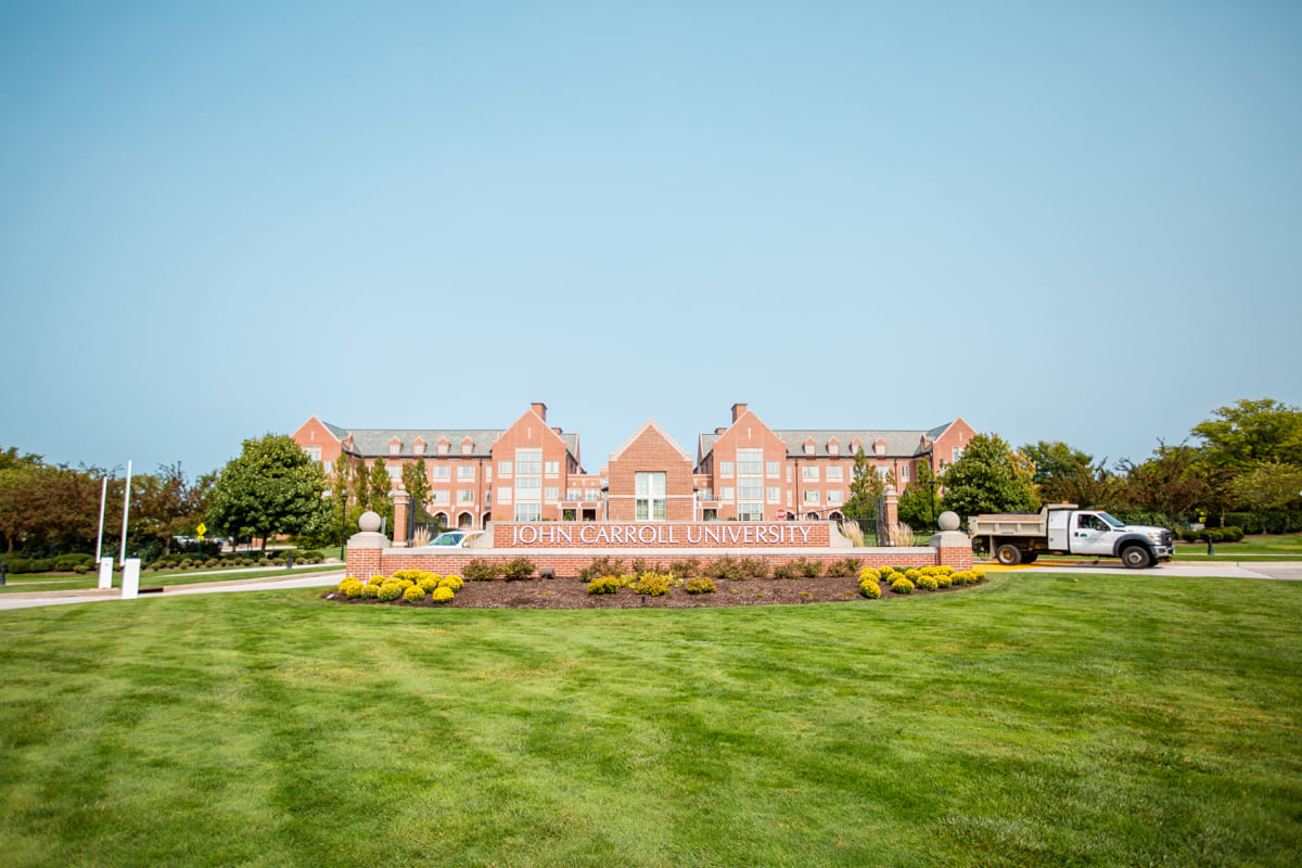 Green lawn and landscaping near sign at john carroll university