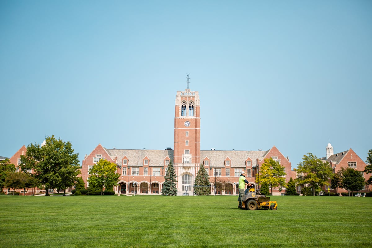 commercial landscaping crew mows lawn at university