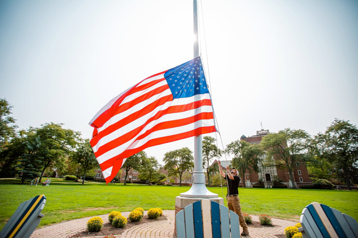 commercial landscaping crew raises flag at college campus