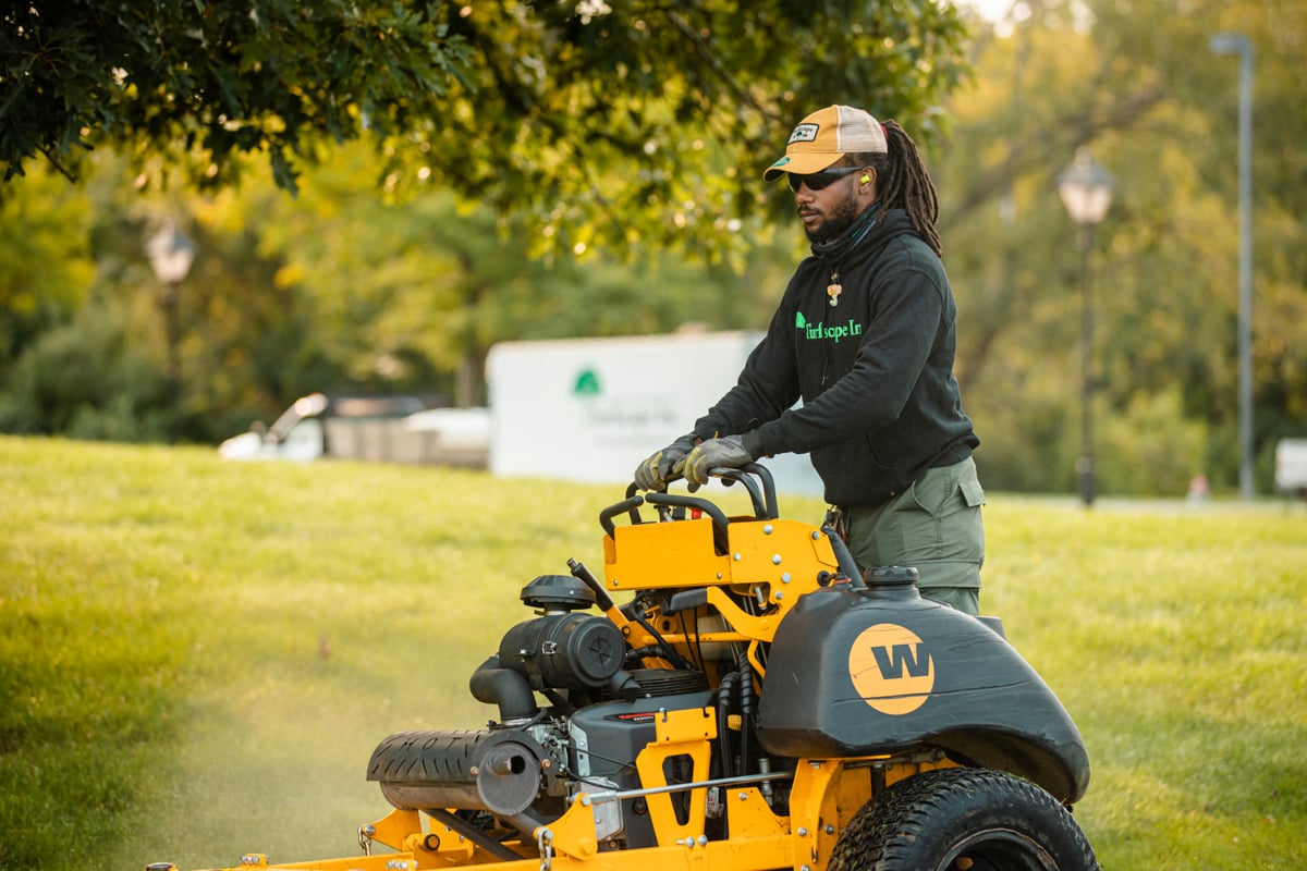 landscape maintenance team mows lawn 