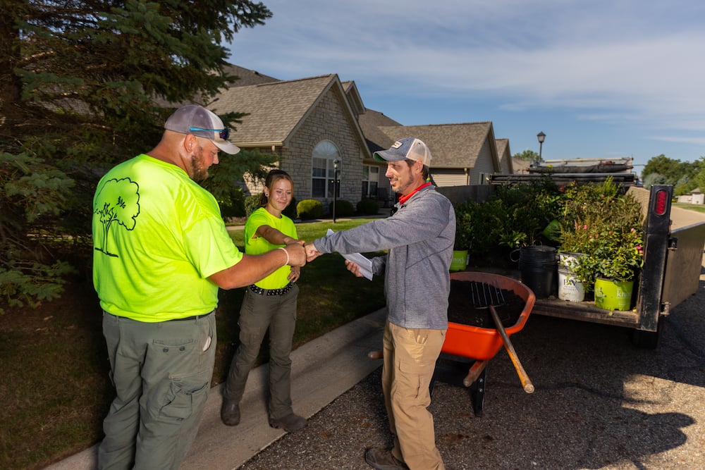 landscaping team meet with plantings and mulch in background