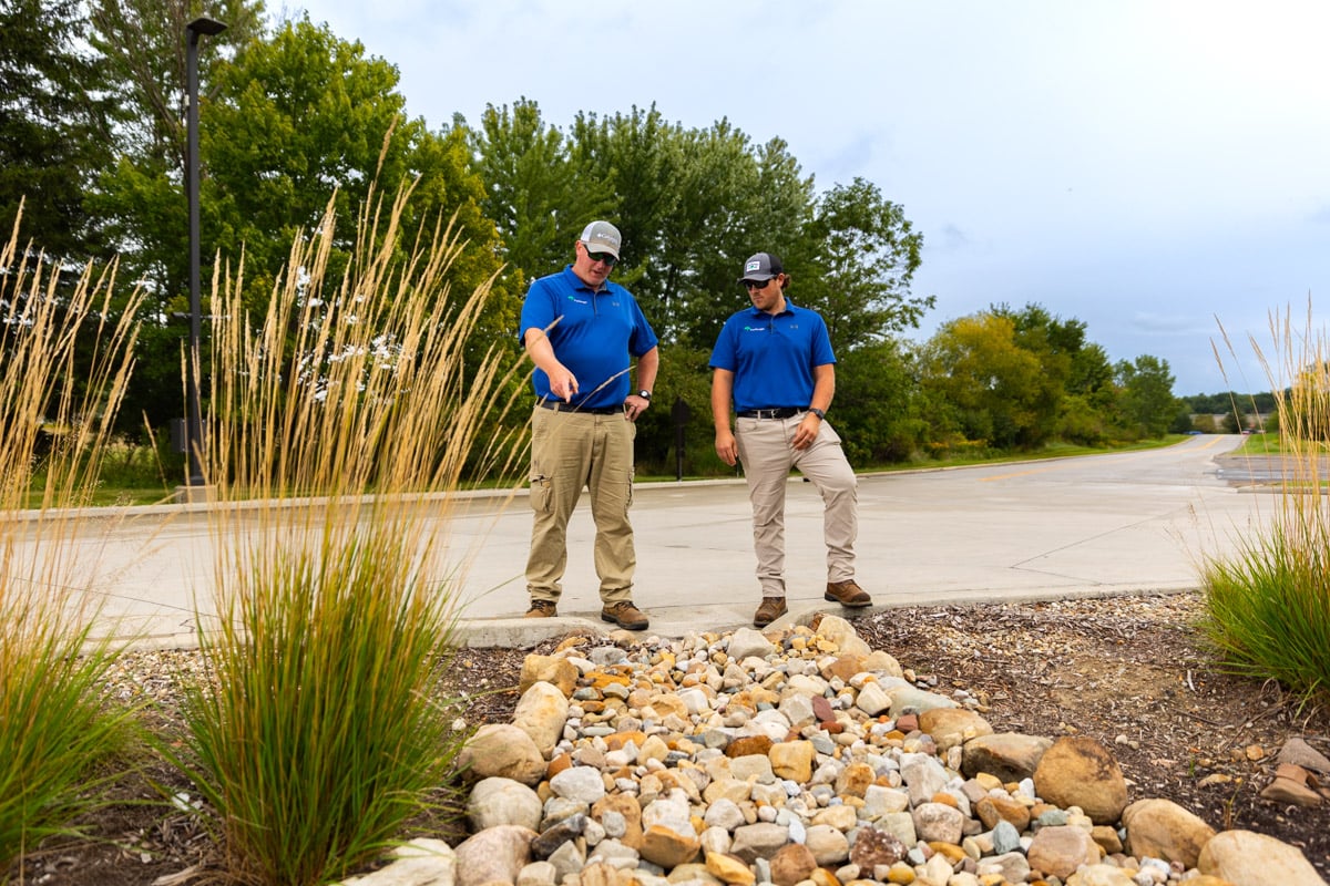 Account managers inspecting dry creek drainage area