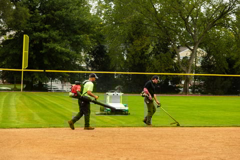 Autonomous commercial robotic mower university crew mowing and blowing athletic field