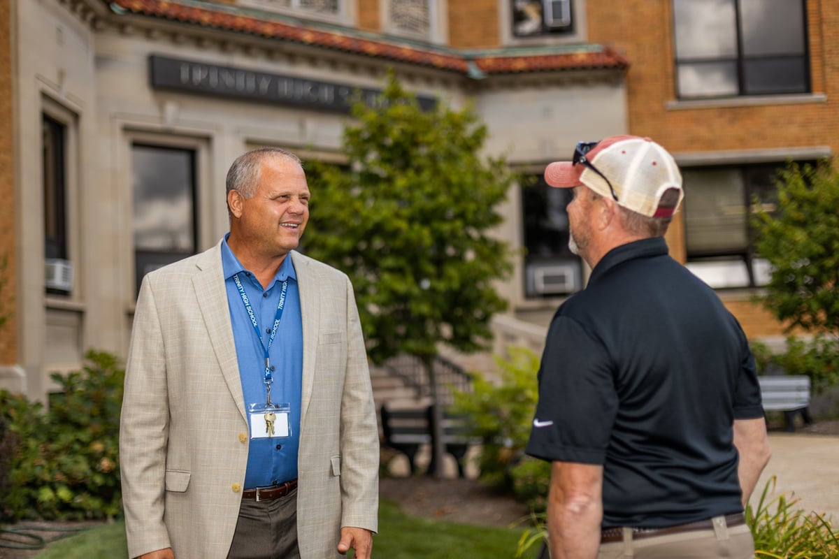 client and commercial landscape maintenance crew leader talk at high school