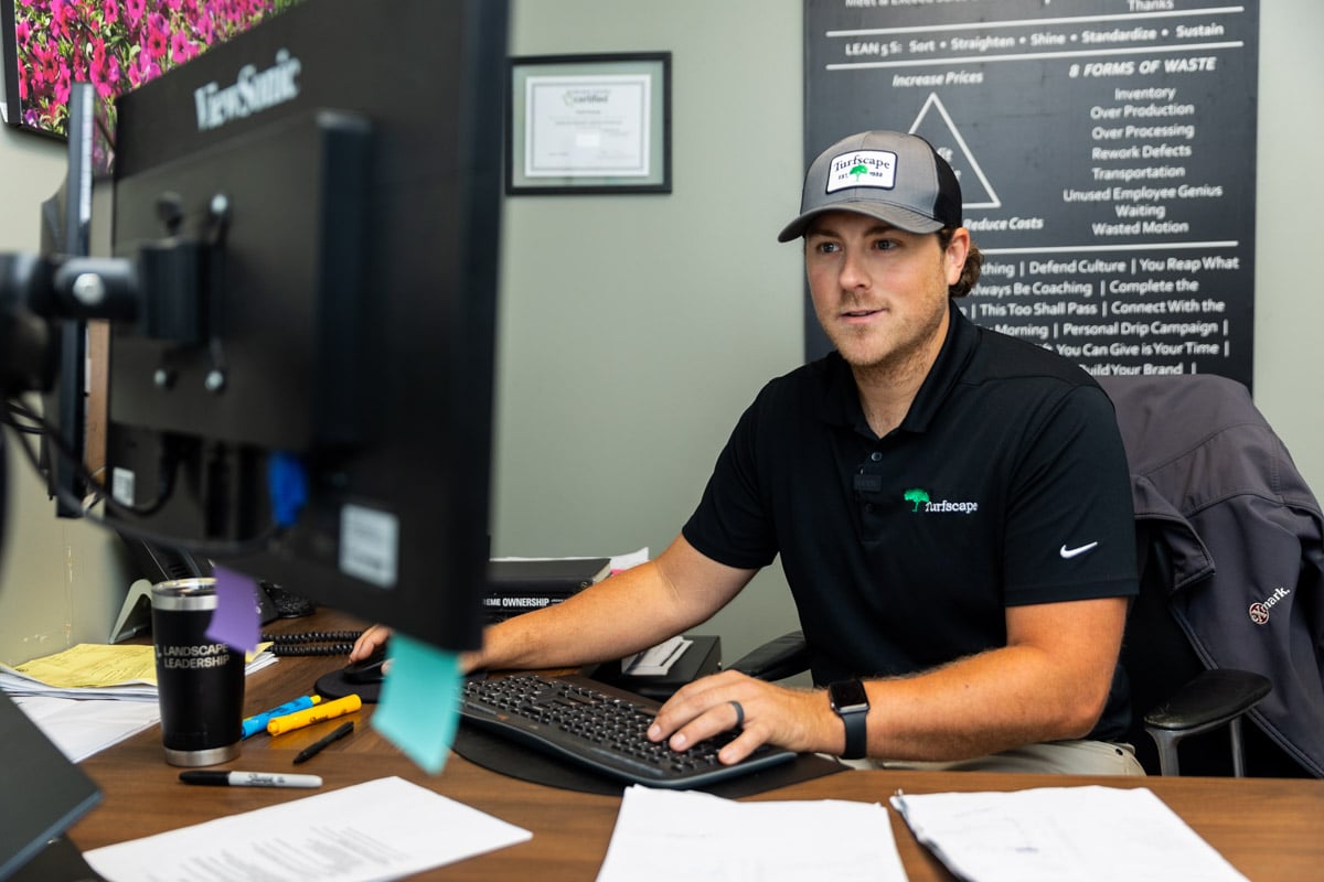 Commercial landscaping account manager sitting at computer