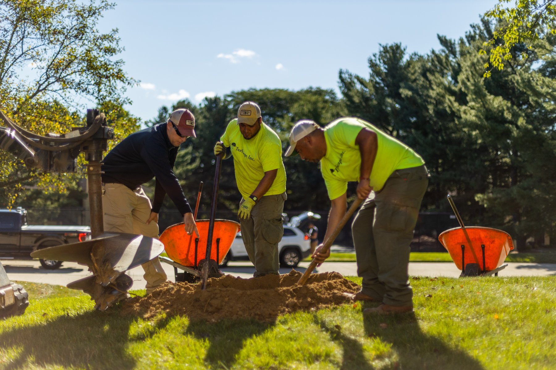 landscape crew digging hole to plant tree