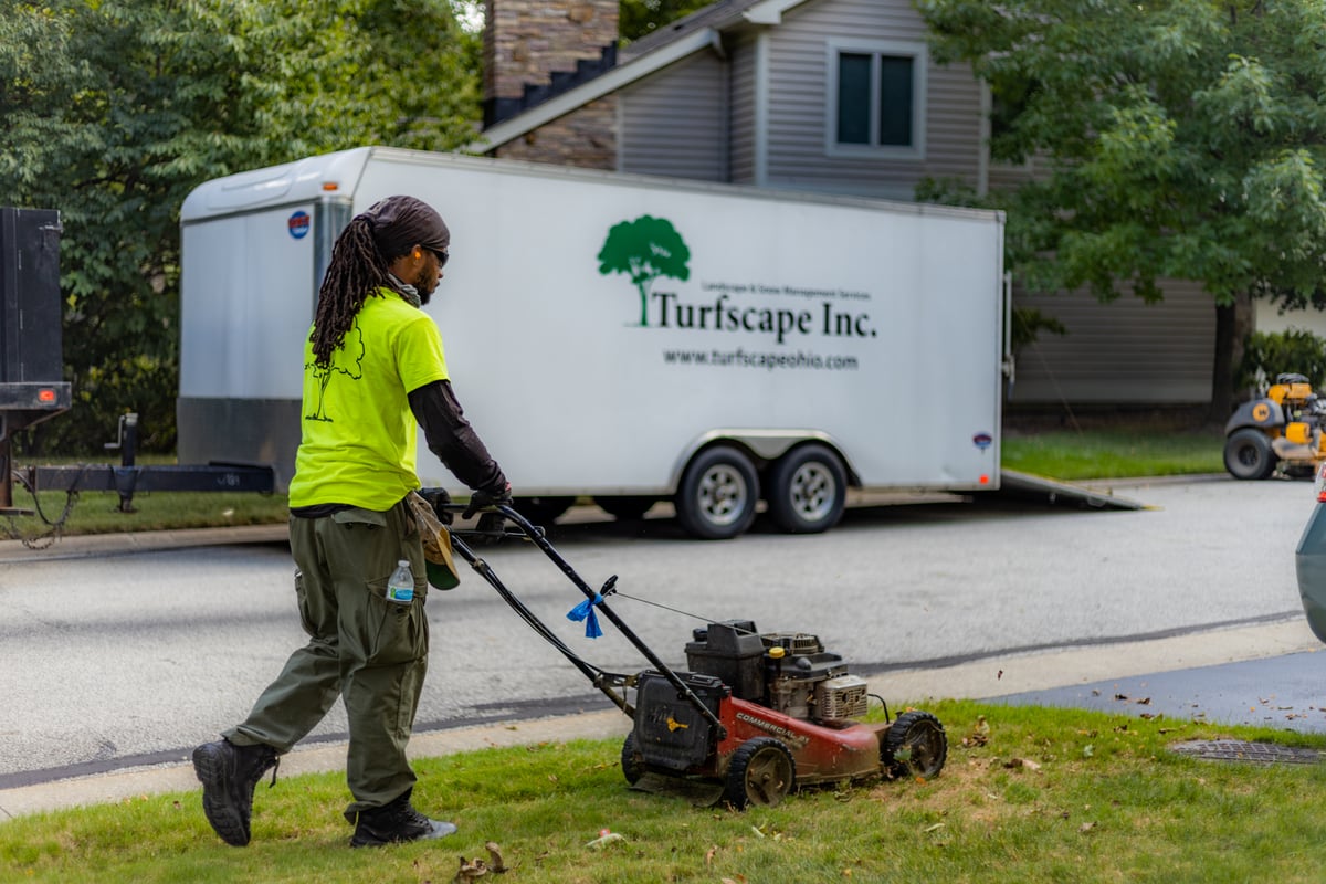 landscape team mowing with push mower