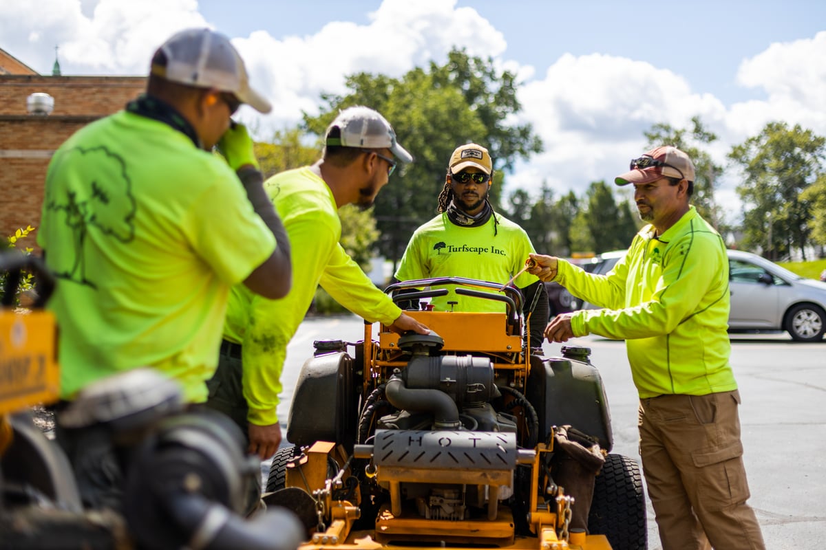 Crew talking near riding mower