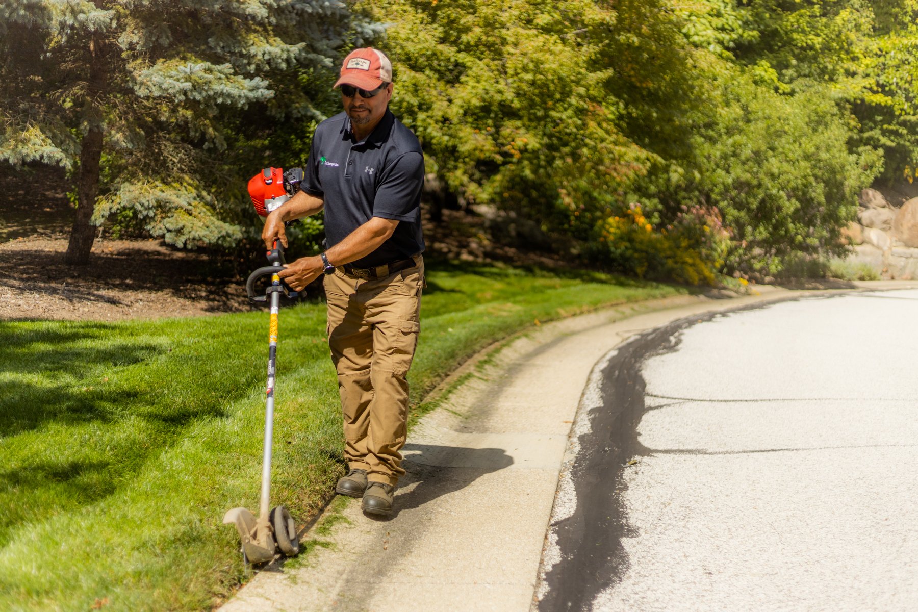 Crew weedeating edging sidewalk HOA