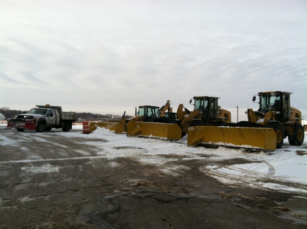 loaders and snow plow trucks on commercial property