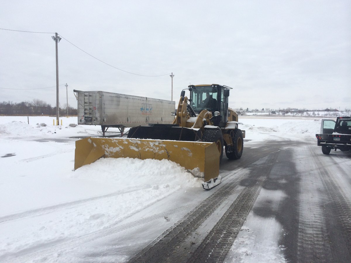 large front loader pushes snow in parking lot