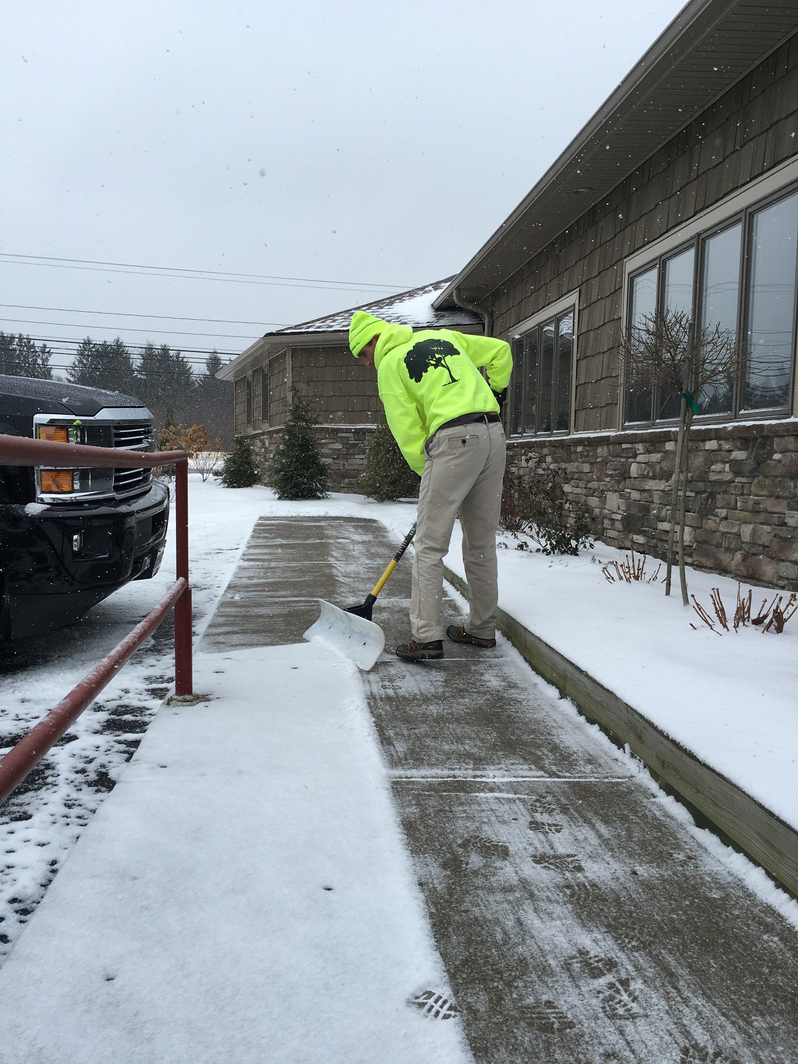 Staff shoveling snow at commercial building