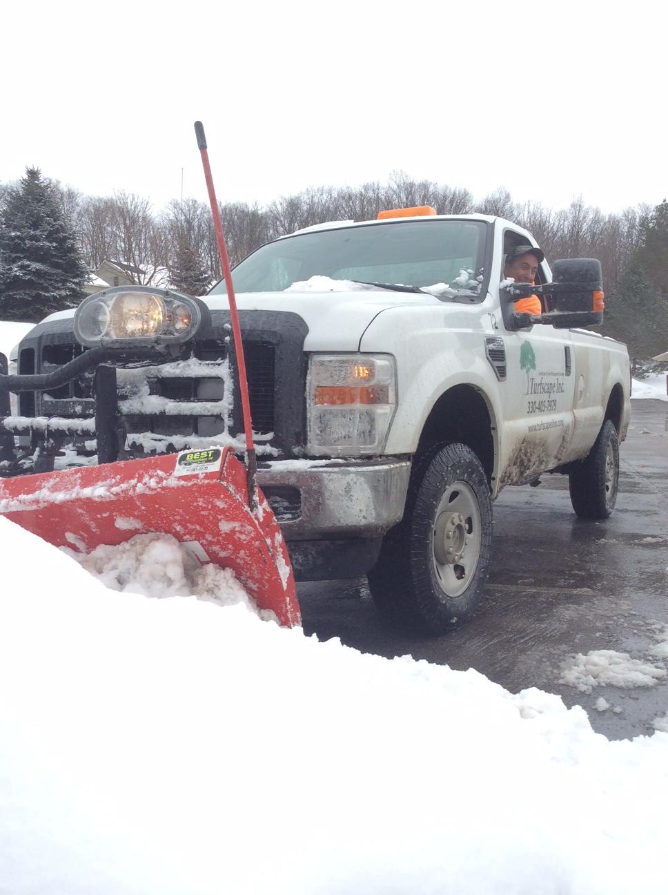 snow removal team piles snow in commercial parking lot